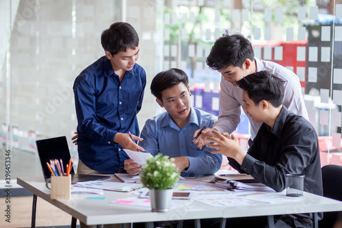 Group of young asian businessman collaborating on project in office.