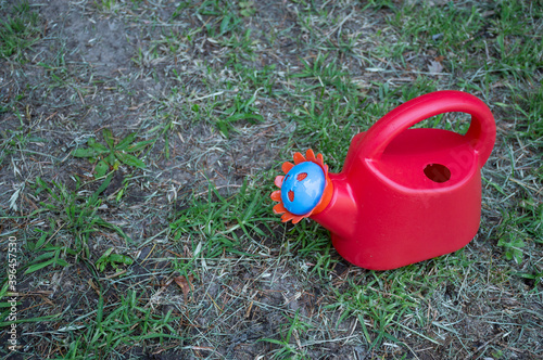 Obraz na płótnie Red toy watering can in a garden w salonie
