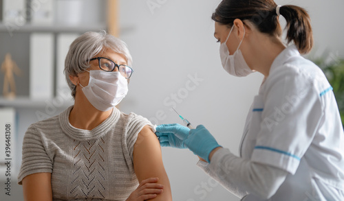 Obraz na płótnie Doctor giving a senior woman a vaccination