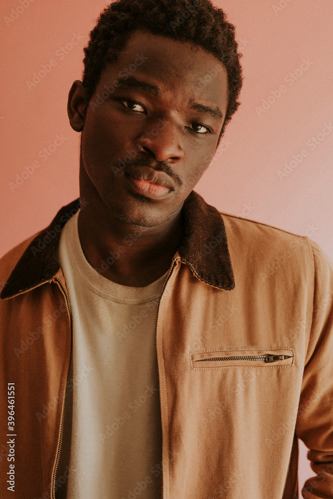 Obraz premium Black man in brown jacket mockup on pink background studio shot