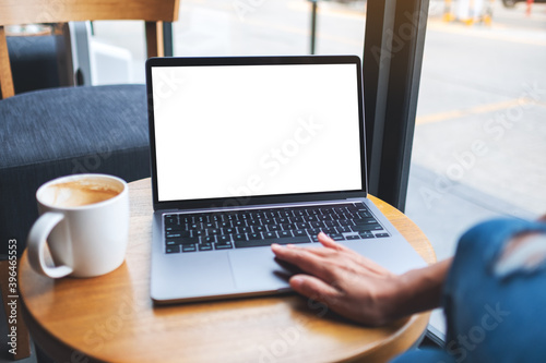 Mockup image of a hand touching on laptop computer touchpad with blank white desktop screen