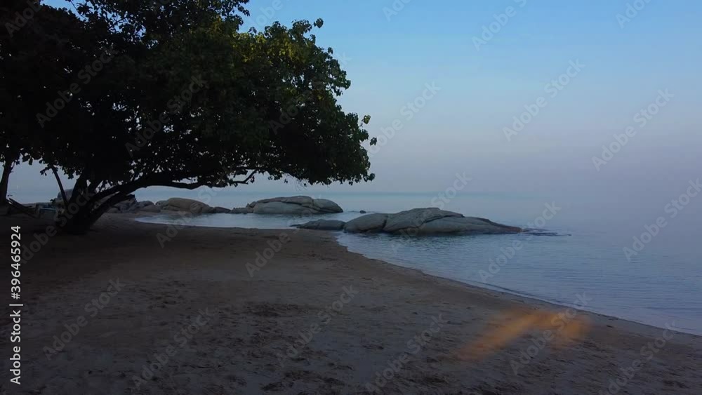Low along empty Thai beach under trees ocean and sky merged into one Low along empty Thai beach under trees ocean and sky merged into one