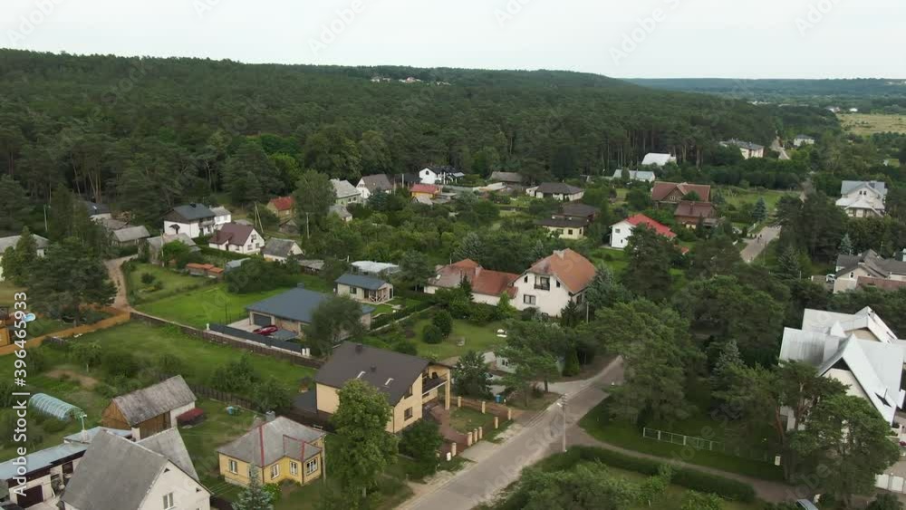 Aerial drone side flying view of small living town in sunny day