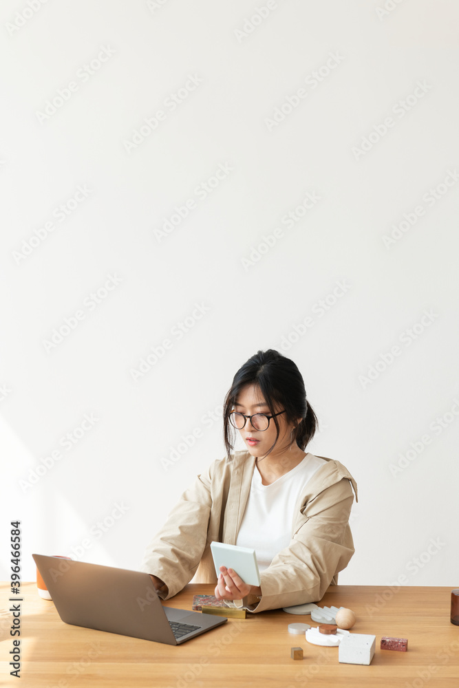 Studious Asian woman working at home using a laptop Studious Asian woman working at home using a laptop