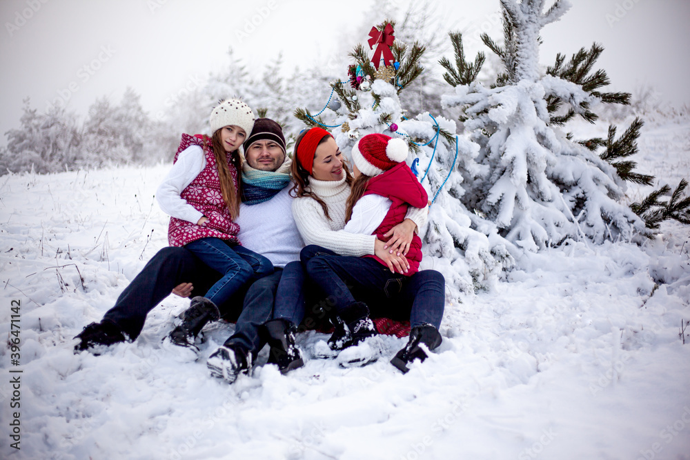 Happy family decorate the Christmas tree outdoor