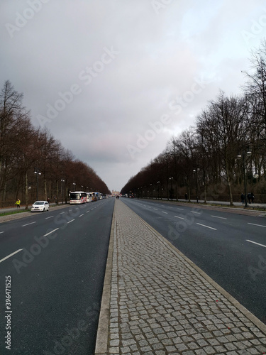 Long empty road in the winter to the brandenburger gate in berlin with parking tourist buses