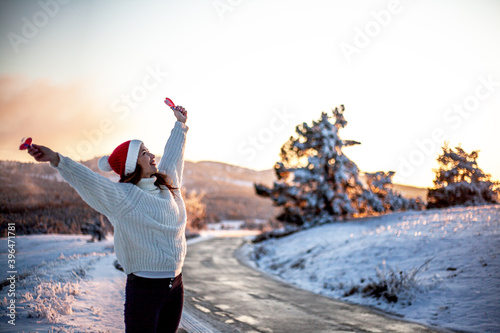 Portrait of beautiful woman holding the symbol of love a red heart in hands on valemtine day against the road to journey. Romantic day for female in snow nature.  photo