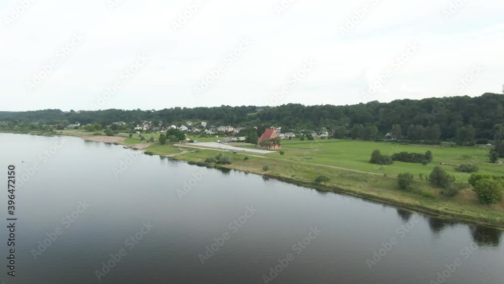 Beautiful slow aerial drone view coming closer from river to red brick church