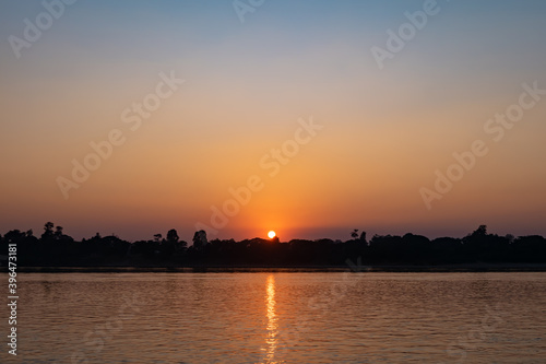 Sunset sky with graduated colors over Mekong riverbank, blue and orange colored sky background.