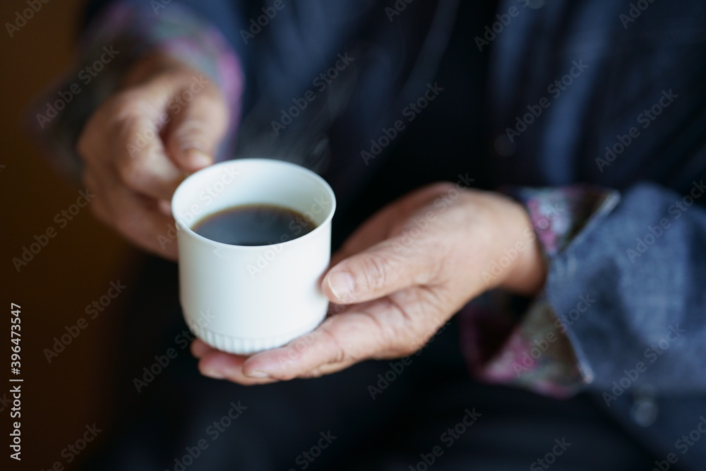 コーヒーカップを持つ高齢女性の手元 コーヒーカップを持つ高齢女性の手元