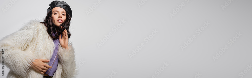 brunette young woman in stylish white faux fur jacket and leather beret posing on grey background, brunette young woman in stylish white faux fur jacket and leather beret posing on grey background,