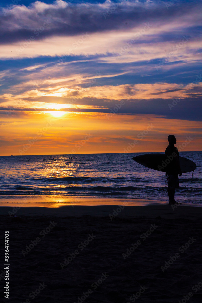 surf boy in sand water beach waves sunset ecuador montañita latin america