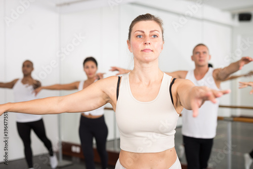 Closeup of group of women and men with their hands up during a ballet class at school © JackF