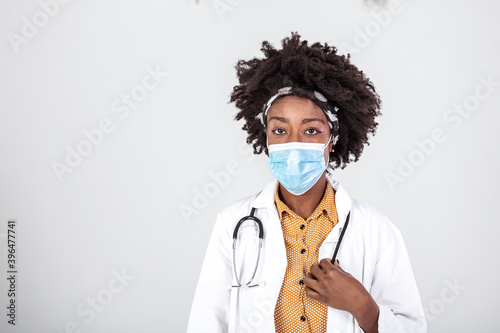 Protect yourself. Portrait of confident black female doctor in face mask over white studio background, copy space. Brave proud black hero physician on grey, healthcare safety, medicine protection © Graphicroyalty