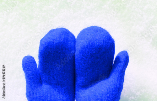 blue mittens lie on the snow. mitten lying on the snow in winter. Holiday Decorations Christmas and New Year Traditions Panoramic Banner Free Space Text Top View Flst lay. Christmas winter background