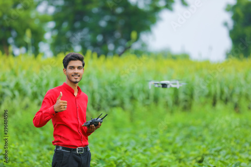 Indian agronomist using drone and showing thumps up at agriculture field