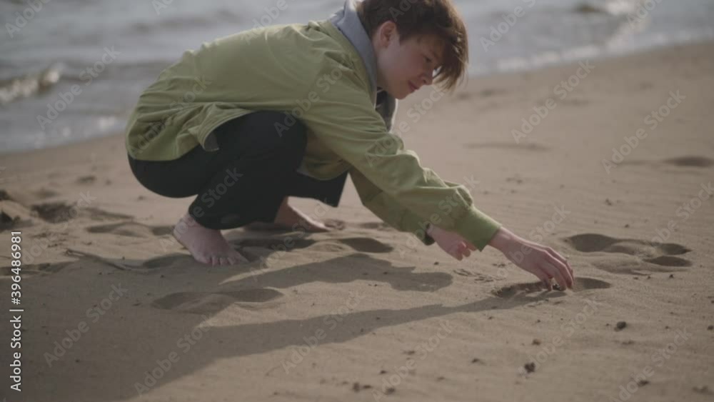 Young woman releases a small frog from her hands Young woman releases a small frog from her hands