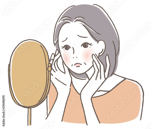 鏡を見て悩むシニア女性