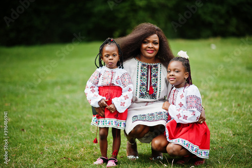 African mother with daugters in traditional clothes at park. photo