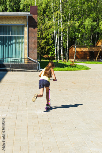 The girl is riding a scooter