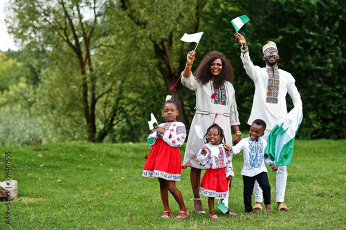 Photography African family in traditional clothes with nigerian flags at park