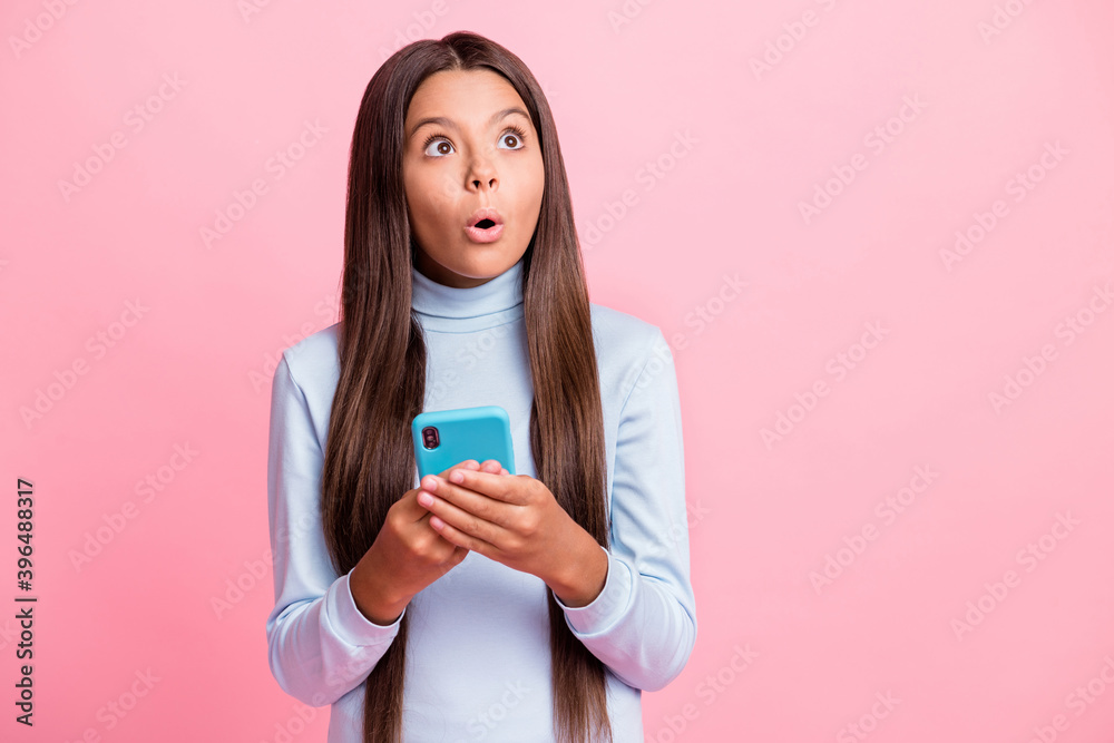 Portrait of pretty worried stunned girl using gadget thinking pout lips copy space isolated over pink pastel color background Portrait of pretty worried stunned girl using gadget thinking pout lips copy space isolated over pink pastel color background