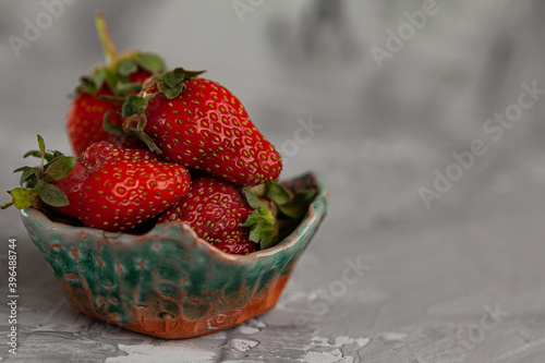 Ripe red strawberries. Bowl filled with juicy fresh ripe red strawberries. strawberries on a grey concrete table. Fresh strawberries photo. Сoncept healthy food