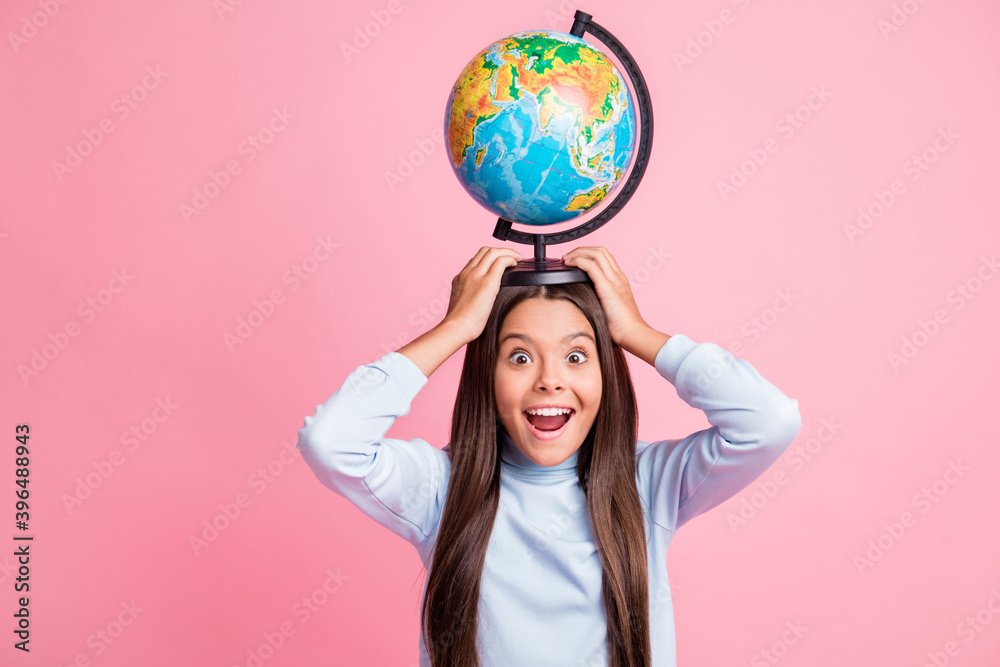 Portrait of pretty cheerful amazed funny girl carrying globe on head having fun isolated over pink pastel color background Portrait of pretty cheerful amazed funny girl carrying globe on head having fun isolated over pink pastel color background