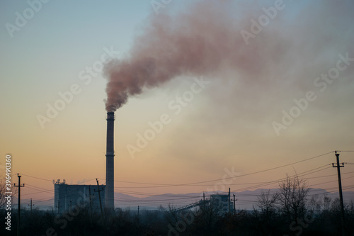 Industrial smoke stack of coal power plant. Burning coal. Sunset in the background
