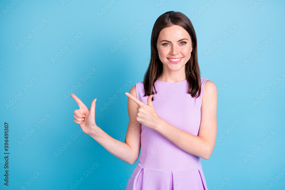 Photo of charming cheerful woman beaming smile point fingers empty space follow isolated on blue color background Photo of charming cheerful woman beaming smile point fingers empty space follow isolated on blue color background
