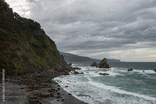 natural beach with cliff has a dramatic effect with the clouds
