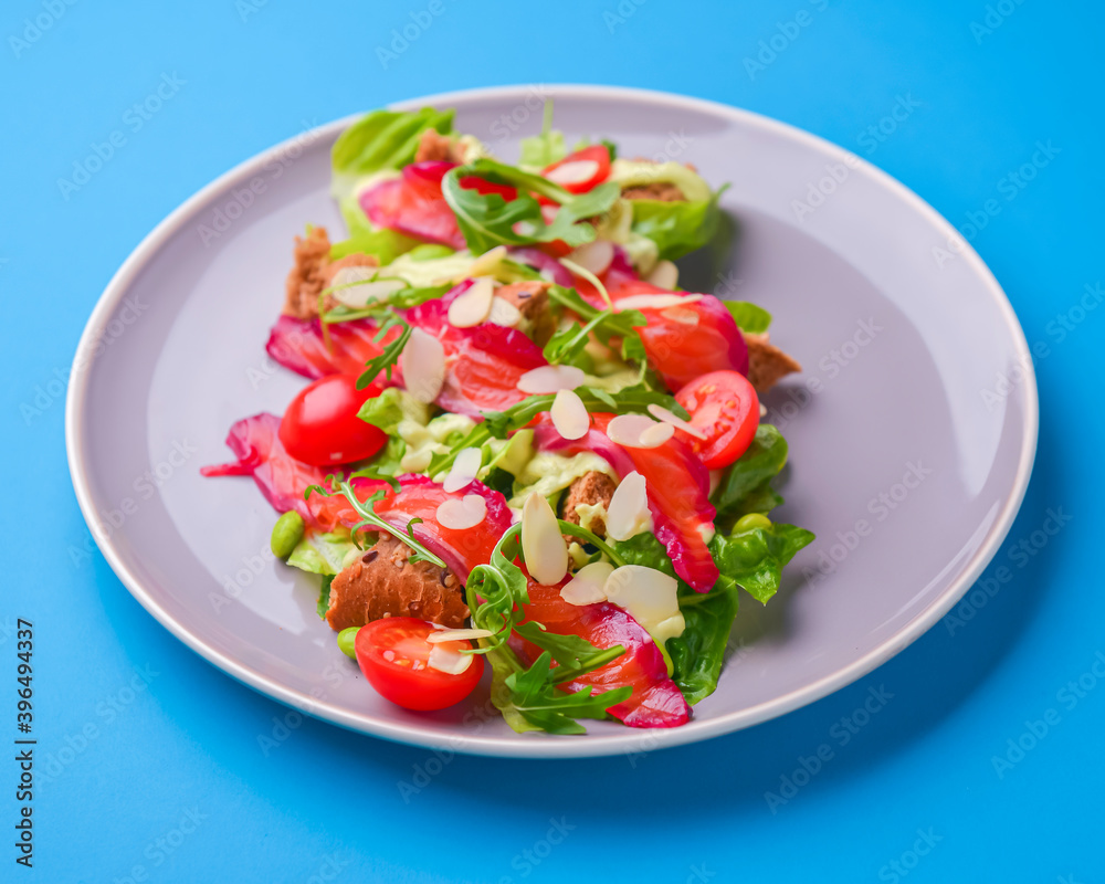 Fresh salad with smoked salted salmon, tomatoes and pumpkin seeds. Served on a gray plate over gray texture background. Fresh salad with smoked salted salmon, tomatoes and pumpkin seeds. Served on a gray plate over gray texture background.
