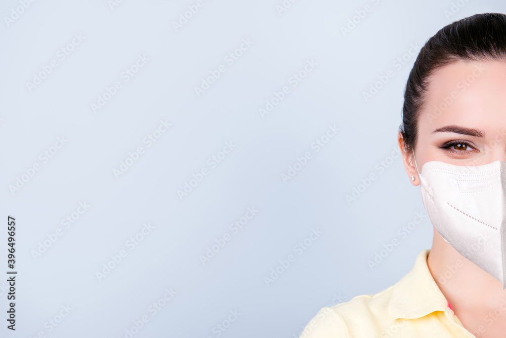 Half face cropped portrait of young brunette wearing safety medical mask isolated on light background Half face cropped portrait of young brunette wearing safety medical mask isolated on light background