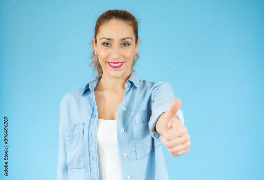 Enthusiastic motivated attractive young woman giving a thumbs up gesture of approval and success with a beaming smile Enthusiastic motivated attractive young woman giving a thumbs up gesture of approval and success with a beaming smile
