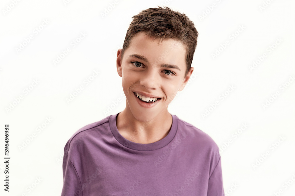 Close up portrait of happy teenaged disabled boy with cerebral palsy smiling at camera, posing isolated over white background Close up portrait of happy teenaged disabled boy with cerebral palsy smiling at camera, posing isolated over white background