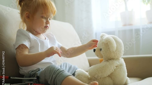 Redhead girl plays doctor with teddy bear toy patient