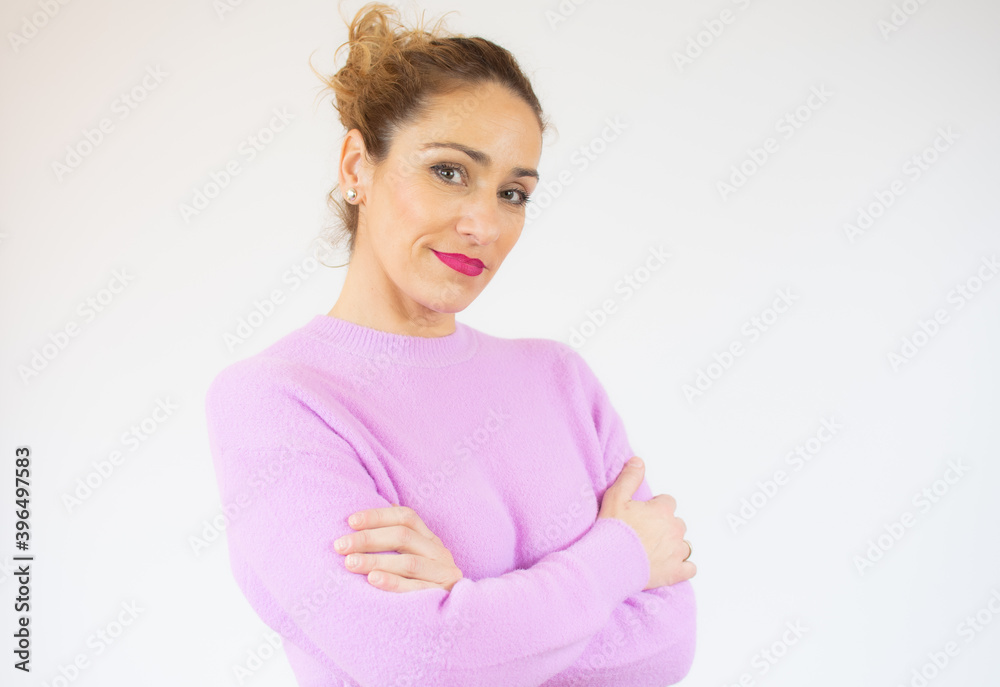 Obraz premium Portrait of a smiling young woman standing with arms folded isolated over white background