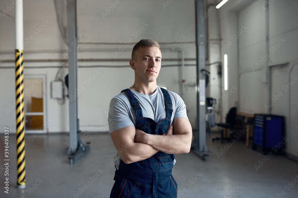 Young caucasian mechanic on car service station background Young caucasian mechanic on car service station background