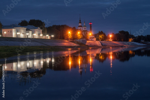 embankment of an ancient Russian city reflected in the river at night