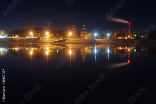 embankment of an ancient city reflected in the river at night