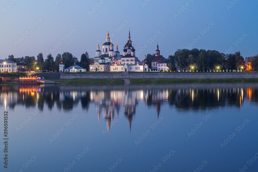 embankment of an ancient city reflected in the river in the evening