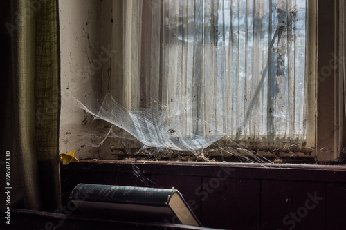 windowsill with old curtains and cobwebs in a house