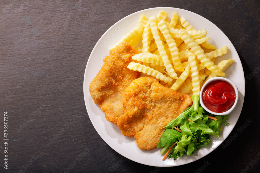 plate of fried breaded chicken meat or Schnitzel with french fries and salad plate of fried breaded chicken meat or Schnitzel with french fries and salad