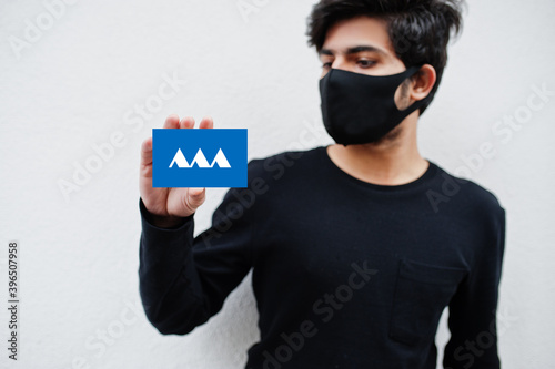Japanese man wear all black with face mask hold Yamagata flag in hand isolated on white background. Prefectures of Japan сoronavirus concept. photo
