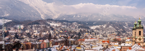 Panoramic view of famous colourful houses and snow-capped alpine mountain tops in the background in the historic city center of scenic Innsbruck on a beautiful sunny day with blue sky, Tyrol, Austria