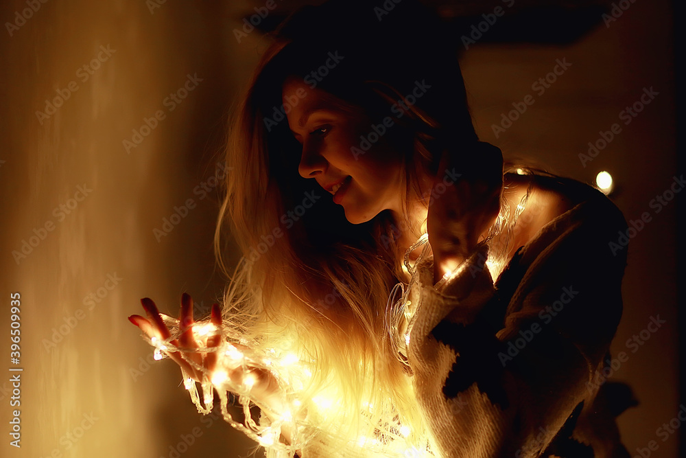 Fototapeta premium cozy Christmas evening girl / home New Year evening, model in a cozy house, evening light