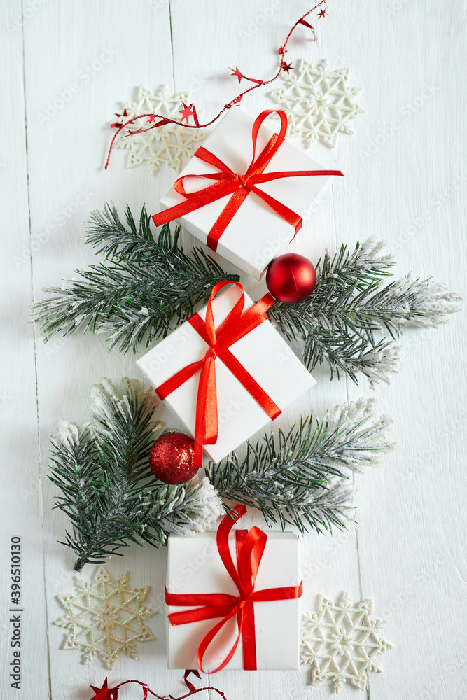 Christmas gift box, fir tree branches, red decorations on white wooden background Christmas gift box, fir tree branches, red decorations on white wooden background