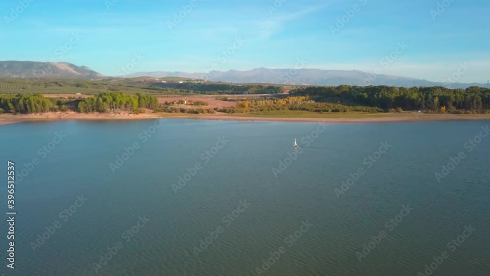Aerial view of a sailing boat in a lake of the south of Spain on a sunny day. Aerial view of a sailing boat in a lake of the south of Spain on a sunny day.