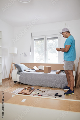 Handyman worker assembling furniture in new apartment, moving in and being hardworking.