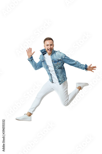attractive crazy man in denim t-shirt jeans jumping high isolated on white background